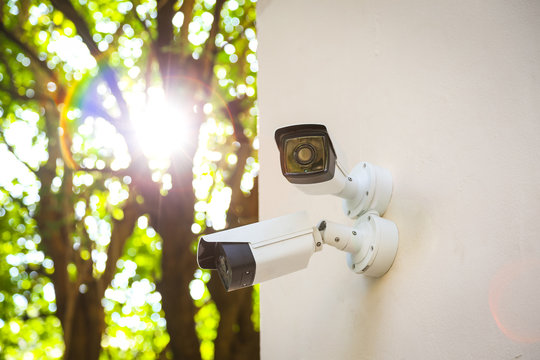Outdoor CCTV monitoring, security cameras with sunlight flare.