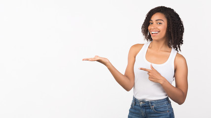 Excited black girl pointing at hand for promo