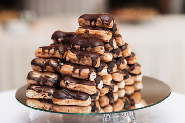 delicious sweet eclairs with chocolate cream and whipped cream inside