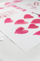 Greeting card for Valentine's Day. Pink hearts painted with watercolor paints.