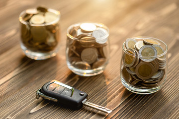 New car keys pile of coin on wooden table. Car financial, Car purchase, or car rental concept