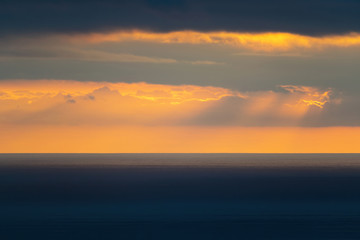 Naklejka na ściany i meble Long aerial view of low clouds over Tasman sea at Piha in sunset light