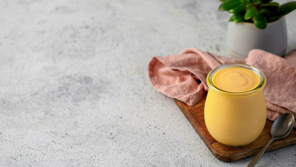 Yellow mango lassi on gray background. Indian mango yogurt drink with copy space left.