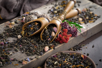 Dry tea leaves on a table in a composition with accessories for tea drinking