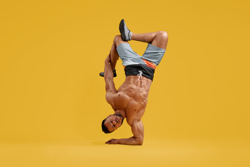 Strong athletic man doing handstand exercise