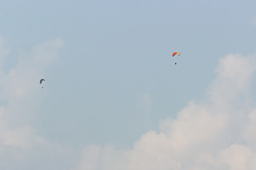 A group of sportsmen flies in the sky in a professional suit on a paraglider. Paragliding Sport Concept for advertising