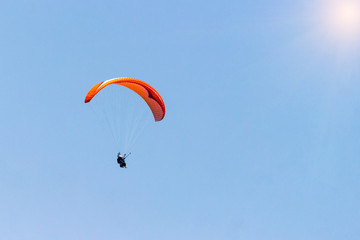 A sportsman flies in the sky in a good suit on a paraglider. Paragliding Sport Concept