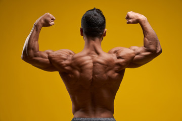 Shirtless man demonstrating muscular arms and shoulder