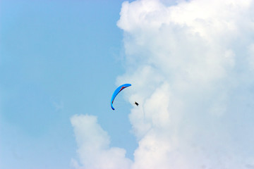 A sportsman flies in the sky in a good suit on a paraglider. Paragliding Sport Concept