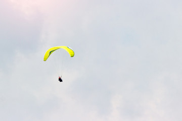 A sportsman flies in the sky in a good suit on a paraglider. Paragliding Sport Concept
