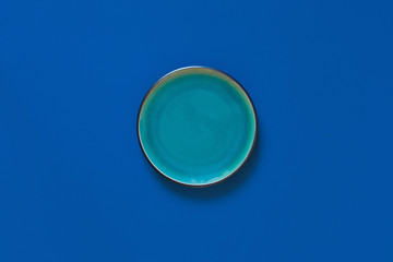 Empty flat and deep plates on a blue background.