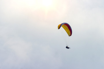 A sportsman flies in the sky in a good suit on a paraglider. Paragliding Sport Concept