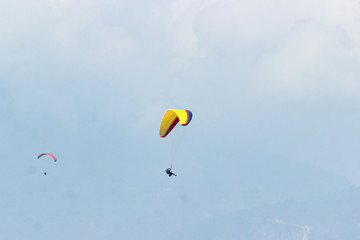 A group of sportsmen flies in the sky in a professional suit on a paraglider. Paragliding Sport Concept for advertising