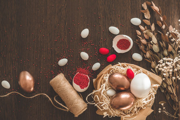 Happy Easter. Flat Lay of Golden Eggs and easter red sprinkle on wooden background