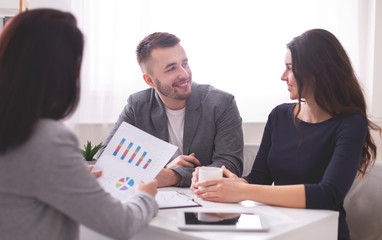 Happy spouses at meeting with financial consultant at bank