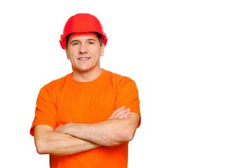 Portrait smiling handsome worker with folded arms, wearing construction helmet and orange informal t-shirt