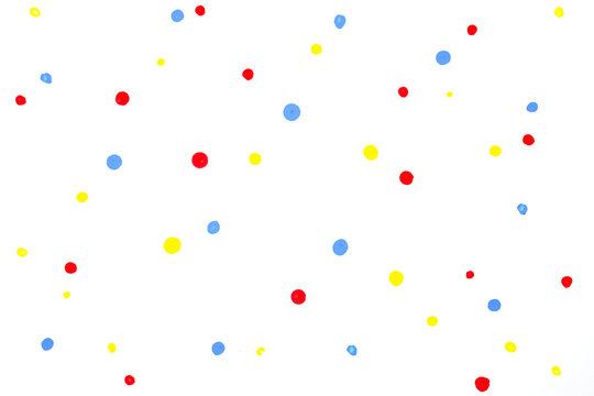 red blue yellow water colour random drop dots on white drawing paper with paper texture.