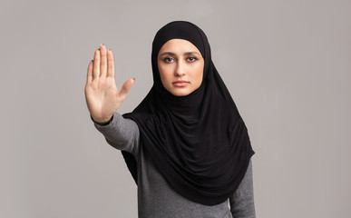 Muslim woman in hijab making stop gesture with her hand