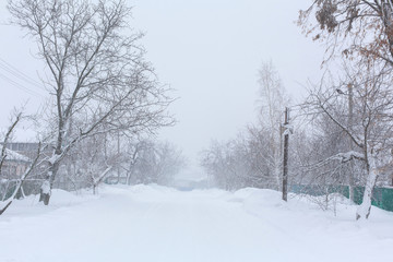 Winter, rural streets are covered with snow. Snow blizzard