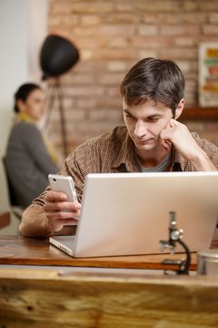 Casual man with mobile and laptop