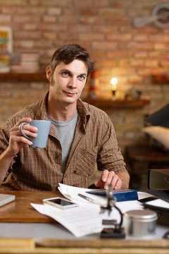 Casual man drinking tea and working