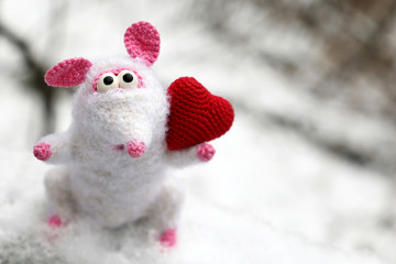 White knitted toy rat with red heart on the snow in winter park, New Year and Valentine card. Chinese Year of Rat, Zodiac symbol 2020