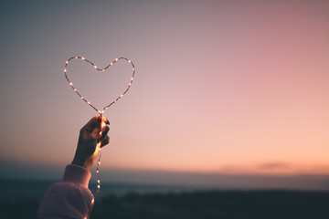 Simbolo del cuore per San Valentino con striscia di luci led. Sfondo del cielo.