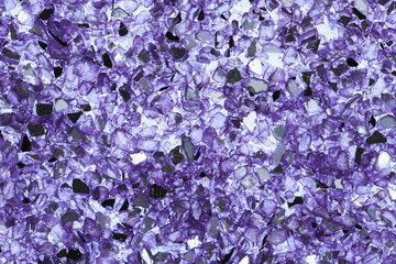 Abstract background of close up detail of fragments of purple crushed glass 
