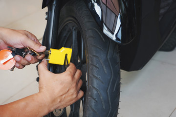 Motorcycle owner use a disc brake lock on a motorbike .Motorcycle Security and Anti-Theft Systems