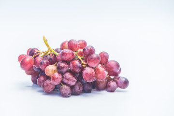 A bunch of red grapes isolated on a white background.