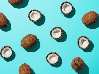 Creative layout of coconuts half on blue background. Tropical pattern, top view or flat lay. Hard...