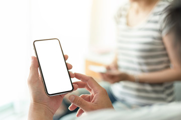 Mockup image blank white screen cell phone.man hand holding texting using mobile on desk at coffee shop.background empty space for advertise text.people contact marketing business,technology 