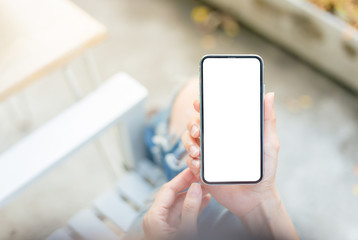 Mockup image blank white screen cell phone.man hand holding texting using mobile sitting at coffee shop.background empty space for advertise text.people contact marketing business,technology 