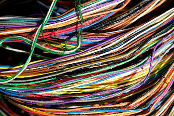 A mess of colorful networking wires and cables in the outdoors and its elements