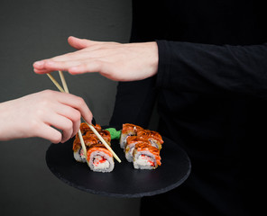 hands hold sushi on blackboard