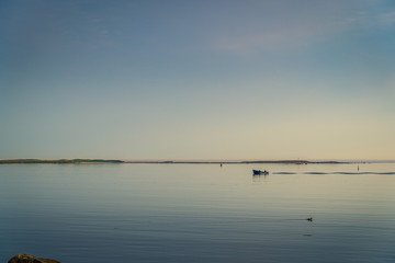 Rocky sea coast shoreline with distant lighthouse.