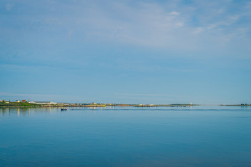Rocky sea coast shoreline with distant lighthouse.