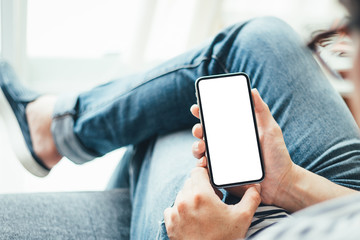 Mockup image blank white screen cell phone.man hand holding texting using mobile sitting at coffee shop.background empty space for advertise text.people contact marketing business,technology 