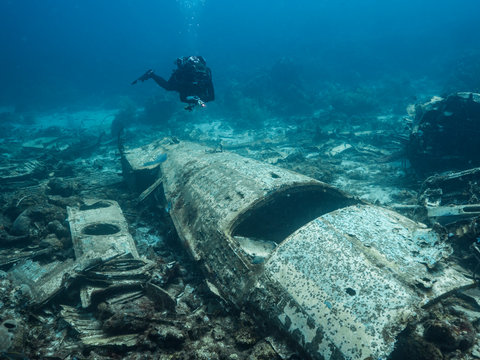 Diver around Elvin's Plane Wreck in coral reef of Caribbean sea around Curacao