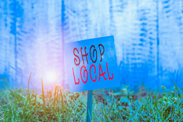 Text sign showing Shop Local. Business photo showcasing a preference to buy locally produced goods and services Plain empty paper attached to a stick and placed in the green grassy land