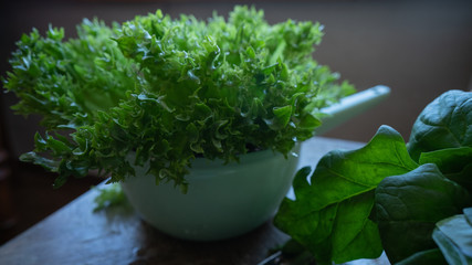 Fototapeta premium Spinach, green salad, and broccoli on wooden table. Still life