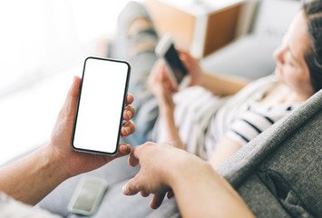 Mockup image blank white screen cell phone.man hand holding texting using mobile sitting at coffee shop.background empty space for advertise text.people contact marketing business,technology 