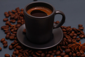 Dark grey cup of coffee and beans on blue table. Coffee shop, espresso, high angle, closeup, template