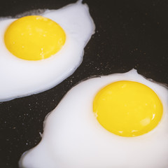 Raw fried eggs.Tasty over easy fried egg in frying pan, closeup