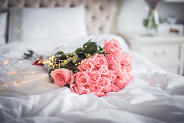 Flowers on clean white bedding.