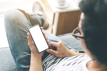 Mockup image blank white screen cell phone.man hand holding texting using mobile sitting at coffee shop.background empty space for advertise text.people contact marketing business,technology 