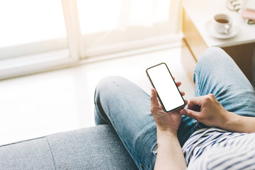 Mockup image blank white screen cell phone.man hand holding texting using mobile sitting at coffee shop.background empty space for advertise text.people contact marketing business,technology 