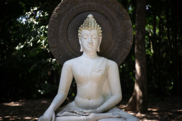 White buddha in the garden of Suan Mok Phalaram temple or Wat Suan Mok Phalaram.