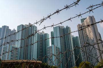 barbwire fence closeup with skyline in background -