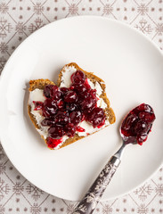 Cranberry jam and cream cheese toast on white plate, top view